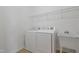 Functional laundry room with appliances, utility sink, and overhead shelving for storage at 125 Station Dr, Morrisville, NC 27560