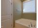 Relaxing main bathroom features a soaking tub next to a bright window at 125 Station Dr, Morrisville, NC 27560