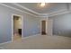 Neutral bedroom features a tray ceiling, and entryways to the main bathroom and walk-in closet at 125 Station Dr, Morrisville, NC 27560
