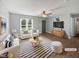 Bright, staged living room with white furniture, modern decor, a ceiling fan, and ample natural light at 125 Wynnridge Dr, Angier, NC 27501