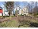 View of the property's backyard, set on a gentle slope between three houses at 132 Fiori Hill S Dr, Hillsborough, NC 27278