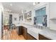 Eat-in kitchen with white marble countertops, apron sink, hardwood floors, and stylish blue and white curtains at 132 Fiori Hill S Dr, Hillsborough, NC 27278
