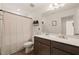 Neutral bathroom featuring vanity with quartz counters, dark cabinets and shower with curtain at 1417 Underbrush Dr, Durham, NC 27703