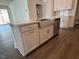 The kitchen island has a stainless sink, white cabinets and modern hardware at 173 Little Crk Dr, Lillington, NC 27546