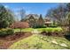 Expansive backyard featuring a lush lawn, mature trees and a stepping stone walkway leading to the home at 2207 Oxford Rd, Raleigh, NC 27608