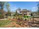 Spacious, fenced backyard showcasing an arbor, manicured greenery, and the home's rear exterior at 2207 Oxford Rd, Raleigh, NC 27608