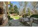 Private backyard features a stone patio, outdoor seating, and lush landscaping creating an ideal space for relaxation at 2207 Oxford Rd, Raleigh, NC 27608