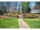 Landscaped backyard featuring a stone path, manicured bushes, and an arbor leading into a garden at 2207 Oxford Rd, Raleigh, NC 27608