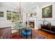 Elegant dining room featuring a glass-top table, fireplace, and large windows with views of the outdoors at 2207 Oxford Rd, Raleigh, NC 27608