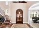 Spacious foyer showcasing a curved staircase, arched doorway, grand rug, and beautiful hardwood floors at 2207 Oxford Rd, Raleigh, NC 27608