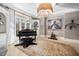 Elegant living room featuring a piano, bay window, custom lighting, unique decor, and tiled flooring at 2207 Oxford Rd, Raleigh, NC 27608