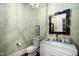 Stylish powder room featuring patterned wallpaper, a decorative mirror, and a white vanity at 2207 Oxford Rd, Raleigh, NC 27608