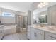 Bright bathroom featuring a soaking tub, a glass-enclosed shower, and double vanity at 228 Nahunta Dr, Apex, NC 27539