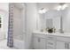 Well-lit bathroom featuring dual sinks, modern fixtures, and a shower with a decorative curtain at 228 Nahunta Dr, Apex, NC 27539