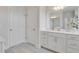 Bright bathroom with white cabinetry, dual doors, and a large mirror above the sink at 228 Nahunta Dr, Apex, NC 27539