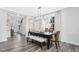 Open-concept dining area with stylish table, bench seating, and a view of the staircase and front entry at 228 Nahunta Dr, Apex, NC 27539