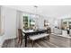Elegant dining room featuring a modern chandelier, a wooden table with seating, and large windows at 228 Nahunta Dr, Apex, NC 27539