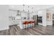 Modern kitchen featuring white cabinets, stainless steel appliances, and a center island with stylish bar stools at 228 Nahunta Dr, Apex, NC 27539