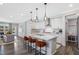 Contemporary kitchen with white cabinets, stainless steel appliances, and island with seating open to the living space at 228 Nahunta Dr, Apex, NC 27539