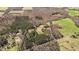 Wide aerial shot showcasing a large property featuring green pastures, wooded areas, and a winding road at 23901 Nc-902, Bennett, NC 27208