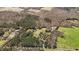 Overhead view of a property featuring wooded land, green pastures, a pond, and various outbuildings at 23901 Nc-902, Bennett, NC 27208