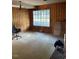 A spacious living room with wood paneling and a large window at 249 Bailey'S Crossroads Rd, Benson, NC 27504