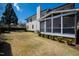 Backyard view of the home with large grassy yard, mature landscaping, and an enclosed porch at 2704 St Marys St, Raleigh, NC 27609
