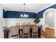 Chic dining room with a long wooden table, stylish chandelier, and wainscoting at 2704 St Marys St, Raleigh, NC 27609