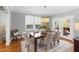 Sunlit dining room with wood floors, table for six, stylish light fixture, and a view to the porch at 2704 St Marys St, Raleigh, NC 27609