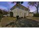 Backyard view of the home with large grassy yard, mature landscaping, and an enclosed porch at 2704 St Marys St, Raleigh, NC 27609