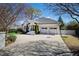 Stately white brick home with a well-manicured lawn, a covered porch, and a two-car garage at 2704 St Marys St, Raleigh, NC 27609