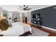Main bedroom with dark accent wall, king bed, ceiling fan, TV and lots of light at 2704 St Marys St, Raleigh, NC 27609