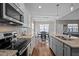 Functional kitchen with stainless steel appliances and granite counters overlooking the dining area at 302 Weaver Ridge Rd, Rougemont, NC 27572