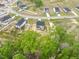 An aerial view of a modern home with a dark roof and light siding, surrounded by lush trees and landscaping at 303 Old Fashioned Way, Lillington, NC 27546