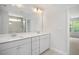 Bright bathroom features double vanity with a large mirror and walk-in shower with glass door at 303 Old Fashioned Way, Lillington, NC 27546