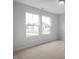 Bright bedroom featuring large windows and neutral carpet flooring at 303 Old Fashioned Way, Lillington, NC 27546