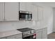 Elegant kitchen featuring stainless appliances, quartz countertops and white cabinetry at 303 Old Fashioned Way, Lillington, NC 27546
