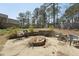 Outdoor fire pit with seating in a backyard surrounded by tall trees at 325 Cobblestone Dr, Spring Lake, NC 28390