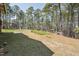 Backyard with mature trees, playhouse, and gazebo surrounded by lush greenery at 325 Cobblestone Dr, Spring Lake, NC 28390