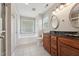 Traditional bathroom with double vanity, mirrors, separate tub, glass block window and tile flooring at 325 Cobblestone Dr, Spring Lake, NC 28390