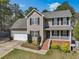 Charming two-story home featuring neutral siding, black shutters, and an attached two-car garage at 325 Cobblestone Dr, Spring Lake, NC 28390
