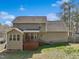 Rear exterior view of a tan home with a deck, patio, and fenced yard at 325 Cobblestone Dr, Spring Lake, NC 28390