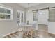 Cozy dining room with hardwood floors, window, table set for four, and a sliding barn door to the dining room at 3428 Singleleaf Ln, Raleigh, NC 27616