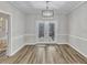 Dining room with hardwood floors, decorative chandelier, and glass paneled doors leading to the outside at 3428 Singleleaf Ln, Raleigh, NC 27616