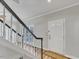 Bright entryway with white door, black and white banister, and wood flooring at 3428 Singleleaf Ln, Raleigh, NC 27616