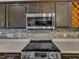 Close up on stainless appliances, tile backsplash and dark wood cabinets at 3428 Singleleaf Ln, Raleigh, NC 27616