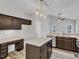Kitchen featuring modern lighting, an island, and dark wood cabinets at 3428 Singleleaf Ln, Raleigh, NC 27616