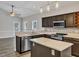 Well-lit kitchen features stainless appliances, dark wood cabinets, and kitchen island at 3428 Singleleaf Ln, Raleigh, NC 27616