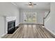 Bright living room featuring a fireplace, hardwood floors, and large windows allowing natural light in at 3428 Singleleaf Ln, Raleigh, NC 27616