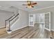 Open-concept living room with hardwood floors, staircase, ceiling fan, and French doors to an adjacent room at 3428 Singleleaf Ln, Raleigh, NC 27616